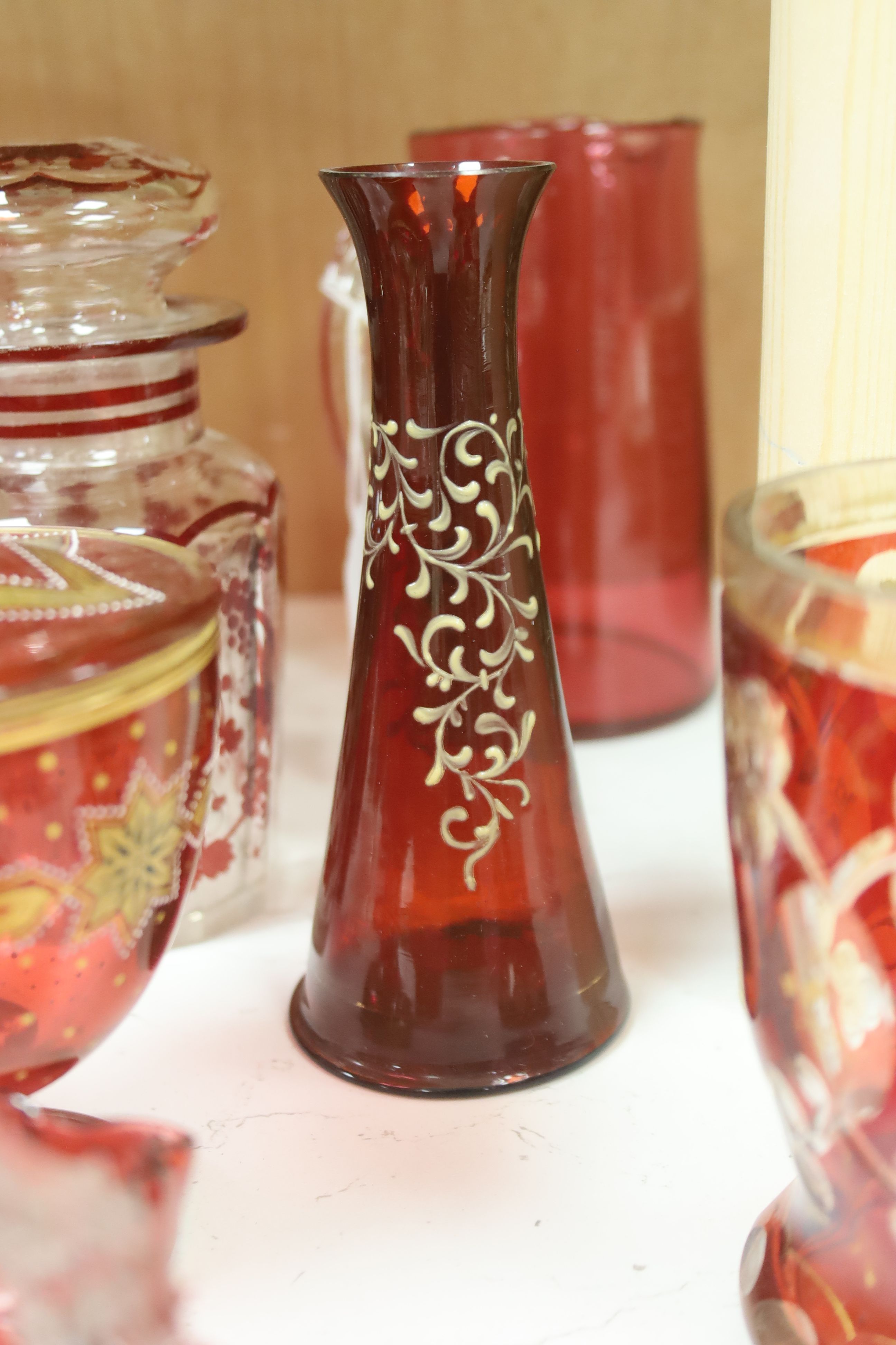 A collection of cranberry and ruby glassware including a 'Mary Gregory' vase